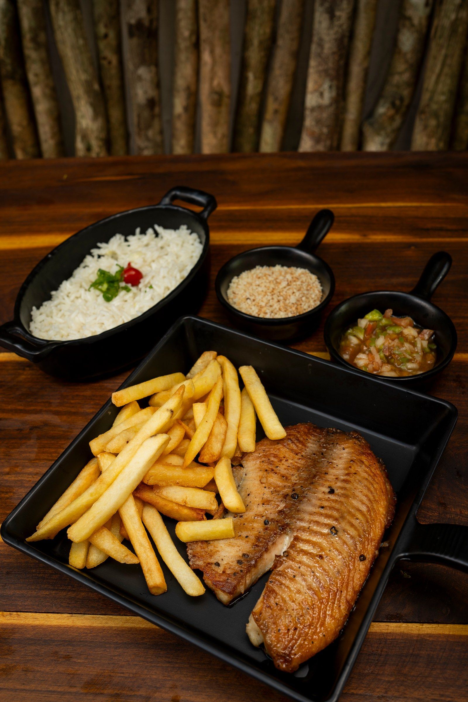 Filé de peixe grelhado com batatas fritas, arroz, farofa e vinagrete